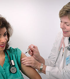 Women receiving a vaccination shot Women receiving a vaccination shot from her Family Female Doctor