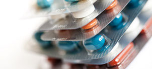 A blister filled with red and white pills A stack of blisters filled with red and white pills sending the idea medicine administration being controled by the Family Doctor