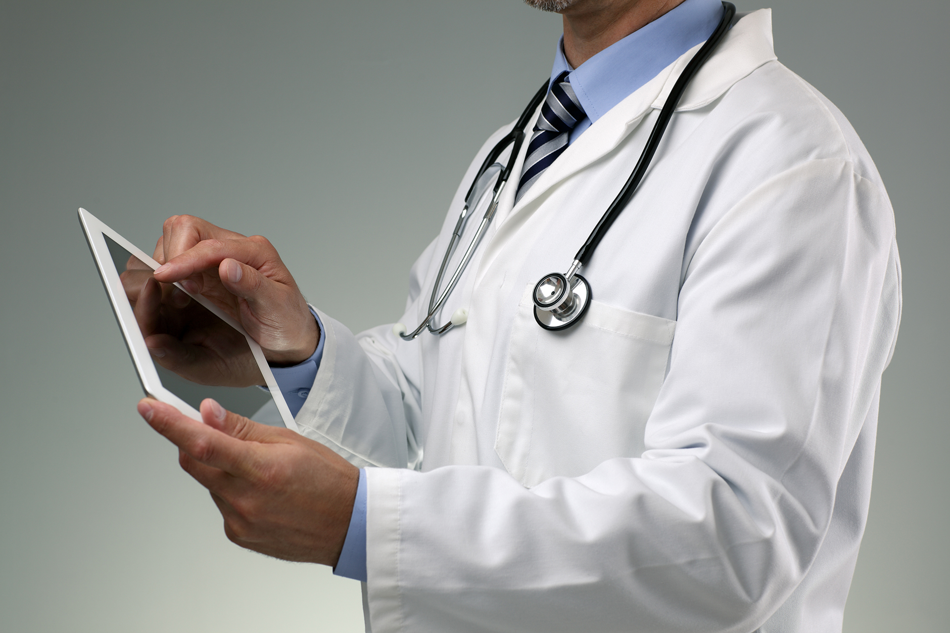 Male doctor analizing a pacient medical data on a tablet Male doctor analizing a pacient medical data on a tablet