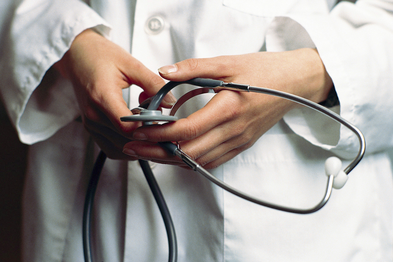 The hands of a female physician with a stethoscope A image with the  hands of a female physician with a stethoscope,  sugesting the idea that the capacity of healing of doctors is anonymous