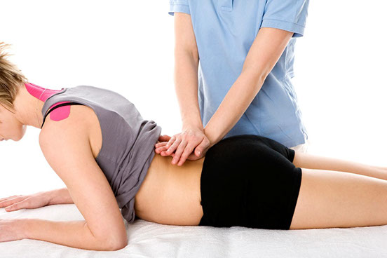 Image of a female patient and the hands of a professional kinetotherapist durng a massage session 